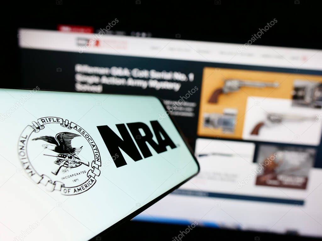 Stuttgart, Germany - 07-09-2023: Mobile phone with logo of National Rifle Association of America (NRA) on screen in front of website. Focus on center-left of phone display.