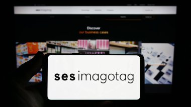 Stuttgart, Almanya - 07-08-2023: İnternet sitesinin önündeki ekranda üzerinde Fransız etiketleme şirketi SES-imagotag SA 'nın logosu olan akıllı telefon tutan kişi. Telefon ekranına odaklan.
