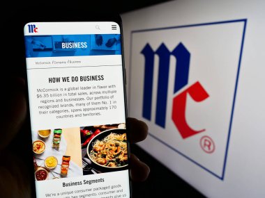 Stuttgart, Almanya - 07-08-2023: ABD 'li McCormick Company Anonim Şirketi' nin web sayfası ile cep telefonu tutan kişi logolu ekranda. Telefon ekranının merkezine odaklan.