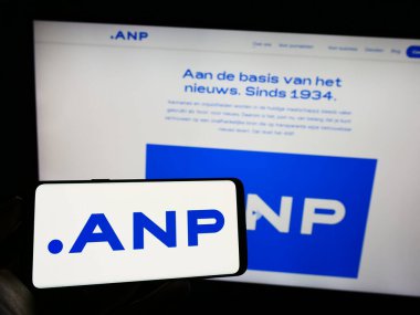 Stuttgart, Almanya - 07-06-2023: İş sayfası önünde ekranda Algemeen Nederlands Persbureau B.V. (ANP) logosu bulunan kişi. Telefon ekranına odaklan.