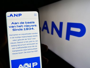 Stuttgart, Almanya - 07-06-2023: Logo önünde ekranda Algemeen Nederlands Persbureau B.V. (ANP) web sayfası bulunan kişi. Telefon ekranının merkezine odaklan.
