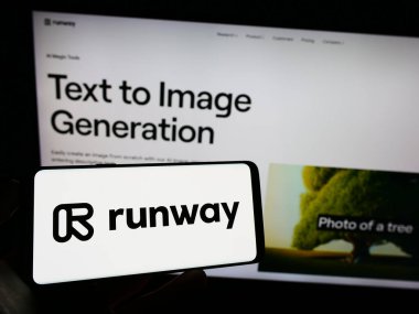 Stuttgart, Germany - 07-06-2023: Person holding cellphone with logo of artificial intelligence company Runway AI Inc. on screen in front of webpage. Focus on phone display. clipart