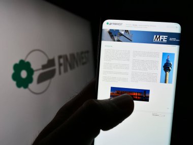 Stuttgart, Almanya - 07-06-2023: İtalyan holding şirketi Fininvest S.P.A. 'nın web sitesi ile akıllı telefonu olan kişi logonun önünde ekranda. Telefon ekranının merkezine odaklan.