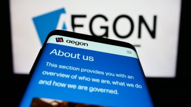 Stuttgart, Almanya - 07-04-2023: Hollandalı finans hizmetleri şirketi Aegon NV 'nin web siteli akıllı telefon iş logosu önünde ekranda. Telefon ekranının sol üst kısmına odaklan.