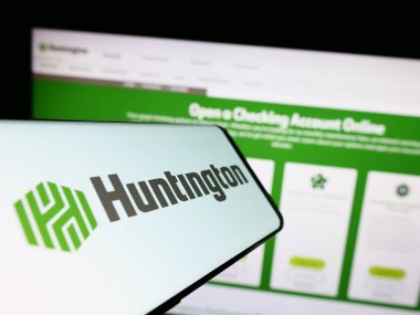 Stuttgart, Almanya - 07-02-2023: Web sitesi önünde ekranda Huntington Bancshare Anonim Şirketi 'nin logosuna sahip cep telefonu. Telefon ekranının merkez sağına odaklan.