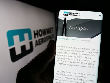 Stuttgart, Almanya - 07-02-2023: ABD 'li firma Howmet Aerospace Inc.' in web sayfası ile akıllı telefon sahibi kişi logo önünde ekranda. Telefon ekranının merkezine odaklan.