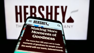 Stuttgart, Almanya - 07-02-2023: ABD gıda şirketinin web sayfalı akıllı telefon The Hershey Company iş logosu önünde ekranda. Telefon ekranının sol üst kısmına odaklan.