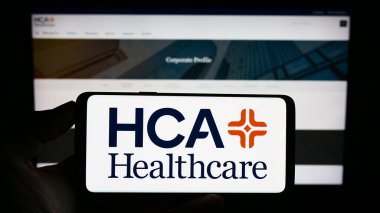 Stuttgart, Almanya - 07-02-2023: Web sitesi önünde ekranda ABD 'li HCA Healthcare Inc. şirketinin logosuna sahip akıllı telefon sahibi kişi. Telefon ekranına odaklan.