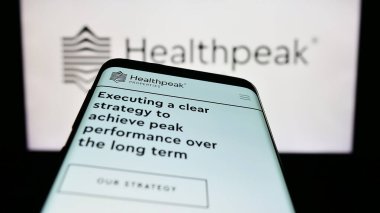 Stuttgart, Almanya - 07-02-2023: Emlak şirketi Healthpeak Properties Inc. 'in web sitesi olan akıllı telefon logonun önünde ekranda. Telefon ekranının sol üst kısmına odaklan.