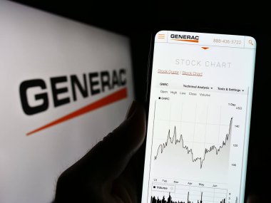 Stuttgart, Almanya - 07-01-2023: ABD 'li firma Generac Holding Inc.' nin web sitesi ile cep telefonu sahibi kişi iş logosu önünde ekranda. Telefon ekranının merkezine odaklan.