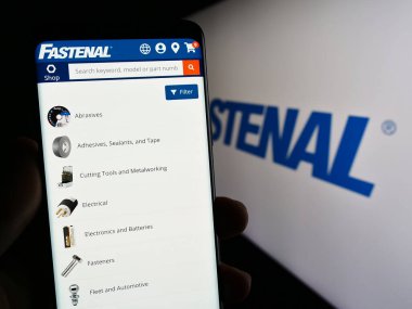 Stuttgart, Almanya - 07-01-2023: ABD 'li dağıtım şirketi Fastenal Company' nin web sayfası olan cep telefonu logosu önünde ekranda. Telefon ekranının merkezine odaklan.