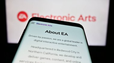 Stuttgart, Almanya - 07-01-2023: Video oyunu şirketi Electronic Arts Inc. (EA) 'in web sayfası olan cep telefonu iş logosu önünde ekranda. Telefon ekranının sol üst kısmına odaklan.