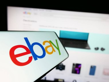 Stuttgart, Almanya - 07-01-2023: Ticari web sitesi önünde ekranda Amerikan e-ticaret şirketi eBay Inc. 'nin logosuna sahip akıllı telefon. Telefon ekranının soluna odaklan.