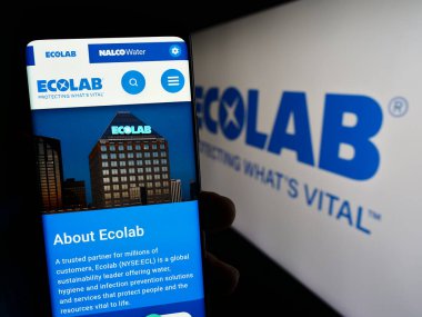 Stuttgart, Almanya - 07-01-2023: ABD 'li su teknolojileri şirketi Ecolab Inc.' in web sayfası ile cep telefonu tutan kişi logonun önünde ekranda. Telefon ekranının merkezine odaklan.