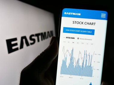 Stuttgart, Almanya - 07-01-2023: ABD 'li Eastman Kimya Şirketi' nin web sitesiyle birlikte logo önünde cep telefonu tutan kişi. Telefon ekranının merkezine odaklan.
