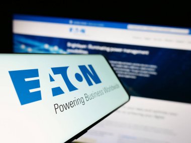 Stuttgart, Almanya - 07-01-2023: Elektrik idaresi şirketi Eaton Corporation plc 'in logosu olan cep telefonu iş dünyasının web sitesinin önünde ekranda. Telefon ekranının soluna odaklan.
