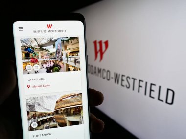 Stuttgart, Almanya - 07-01-2023: Emlak şirketi Unibail-Rodamco-Westfield SE 'nin web sayfası ile akıllı telefon sahibi kişi logolu ekranda. Telefon ekranının merkezine odaklan.