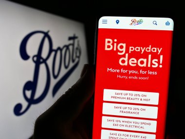 Stuttgart, Almanya - 07-01-2023: İngiliz eczane şirketi Boots UK Limited 'in web sayfası olan cep telefonu logonun önünde ekranda. Telefon ekranının merkezine odaklan.