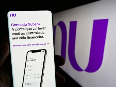 Stuttgart, Almanya - 06-30-2023: Brezilyalı şirket Nu Pagamentos S.A. 'nın (Nubank) internet sayfası olan cep telefonu sahibi. Telefon ekranının merkezine odaklan.