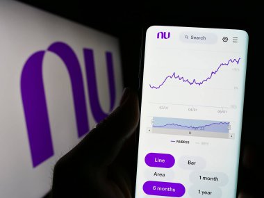 Stuttgart, Almanya - 06-30-2023: Brezilyalı şirket Nu Pagamentos SA 'nın (Nubank) web sitesi ile birlikte logolu akıllı telefonu elinde tutan kişi. Telefon ekranının merkezine odaklan.
