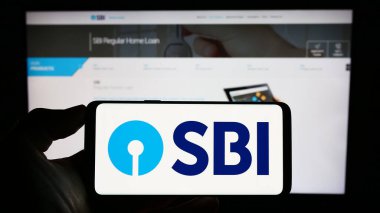 Stuttgart, Almanya - 06-30-2023: Hindistan Devlet Bankası 'nın (SBI) logosu olan cep telefonu sahibi kişi iş sayfasının önünde ekranda. Telefon ekranına odaklan.