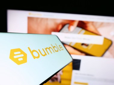Stuttgart, Almanya - 06-28-2023: İş dünyasının web sitesinin önündeki ekranda Amerikalı randevu şirketi Bumble Inc. 'in logosunu gösteren akıllı telefon. Telefon ekranının soluna odaklan.