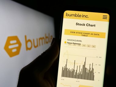 Stuttgart, Almanya - 06-28-2023: ABD 'li çöpçatan şirketi Bumble Inc.' in internet sitesi ile cep telefonu elinde bulunan kişi logonun önünde ekranda. Telefon ekranının merkezine odaklan.