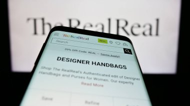 Stuttgart, Almanya - 06-28-2023: ABD 'li e-ticaret şirketi The RealReal Inc.' in web sitesiyle birlikte ticari logo önünde ekranda. Telefon ekranının sol üst kısmına odaklan.