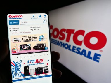 Stuttgart, Almanya - 06-28-2023: ABD 'li Costco Wholesale Corporation şirketinin web sayfası ile akıllı telefon sahibi kişi logo önünde ekranda. Telefon ekranının merkezine odaklan.