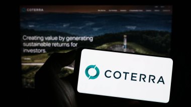 Stuttgart, Almanya - 06-28-2023: ABD 'li petrol ve doğalgaz şirketi Coterra Energy Inc.' in logosunu elinde tutan kişi web sitesinin önünde ekranda. Telefon ekranına odaklan.