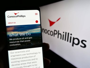 Stuttgart, Almanya - 06-25-2023: ABD petrol ve doğalgaz şirketi ConocoPhillips Company 'nin web sayfası ile akıllı telefon sahibi kişi ekranda logolu. Telefon ekranının merkezine odaklan.
