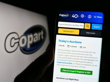 Stuttgart, Almanya - 06-25-2023: ABD 'li otomotiv şirketi Copart Inc.' in web sayfası olan akıllı telefon sahibi kişi logonun önünde ekranda. Telefon ekranının merkezine odaklan.