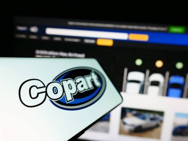 Stuttgart, Almanya - 06-25-2023: Amerikan otomotiv şirketi Copart Inc. 'in logosunu taşıyan cep telefonu iş sitesinin önünde ekranda. Telefon ekranının soluna odaklan.