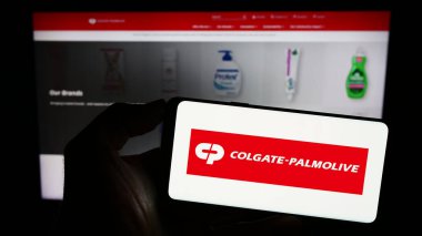 Stuttgart, Almanya - 06-25-2023: İnternet sitesinin önünde Colgate-Palmolive Şirketi logosu olan akıllı telefon sahibi kişi. Telefon ekranına odaklan.