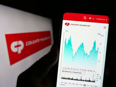 Stuttgart, Almanya - 06-25-2023: Tüketici malları şirketi Colgate-Palmolive Company 'nin web sitesiyle birlikte logolu cep telefonu tutan kişi. Telefon ekranının merkezine odaklan.