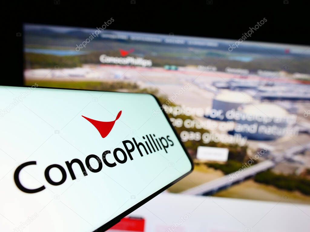 Stuttgart, Germany - 06-25-2023: Cellphone with logo of US oil and gas business ConocoPhillips Company on screen in front of website. Focus on center-right of phone display.