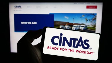 Stuttgart, Almanya: 06-25-2023: Amerikan Cintas Corporation şirketinin logosuyla cep telefonu sahibi kişi iş sayfasının önünde ekranda. Telefon ekranına odaklan.