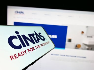 Stuttgart, Almanya: 06-25-2023: Amerikan şirketi Cintas Corporation 'ın logosunu içeren akıllı telefon, iş dünyasının web sitesinin önünde ekranda. Telefon ekranının merkez soluna odaklan.