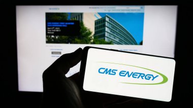 Stuttgart, Almanya: 06-25-2023: Amerikan kamu hizmetleri şirketi CMS Energy Corporation 'ın logosunun bulunduğu cep telefonu web sayfası önünde ekranda. Telefon ekranına odaklan.