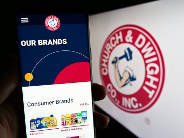 Stuttgart, Almanya: 06-25-2023: ABD 'li tüketici malları şirketi Church Dwight Co. Inc.' nin web sayfası ile cep telefonu elinde bulunan kişi logo ile ekranda. Telefon ekranının merkezine odaklan.