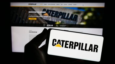 Stuttgart, Almanya - 06-25-2023: ABD 'li ağır ekipman şirketi Caterpillar Inc.' in logosunu taşıyan kişi web sitesinin önünde ekranda. Telefon ekranına odaklan.