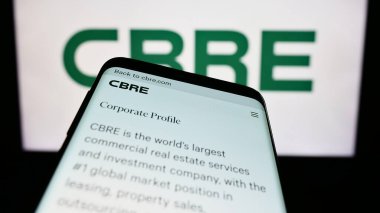 Stuttgart, Almanya - 06-25-2023: ABD 'li emlak şirketi CBRE Group Inc.' nin web sitesi ile birlikte ticari logo önünde ekranda. Telefon ekranının sol üst kısmına odaklan.