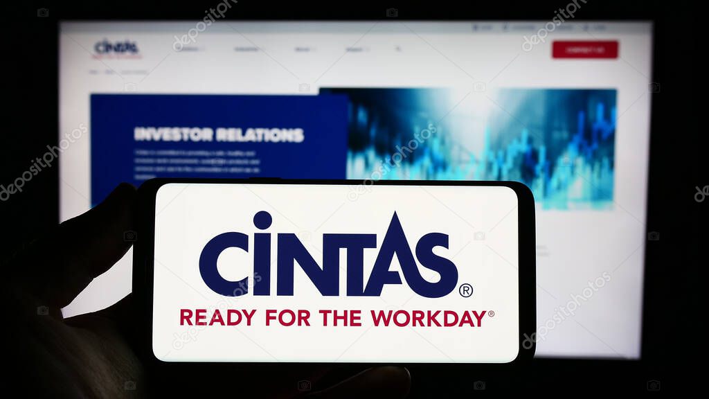 Stuttgart, Germany : 06-25-2023: Person holding smartphone with logo of US company Cintas Corporation on screen in front of website. Focus on phone display.