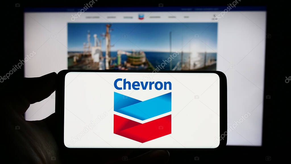 Stuttgart, Germany : 06-25-2023: Person holding cellphone with logo of US energy company Chevron Corporation on screen in front of business webpage. Focus on phone display.
