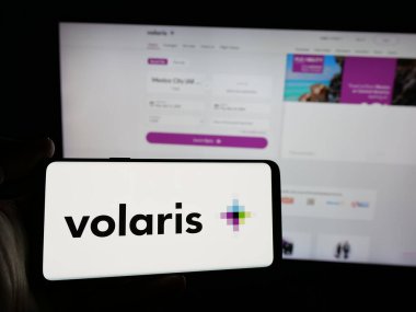 Stuttgart, Almanya - 11-11-2024: İnternet sitesinin önünde ekranda, üzerinde Meksika 'nın düşük maliyetli havayolu şirketi Volaris' in logosu bulunan akıllı telefon sahibi kişi. Telefon ekranına odaklan.