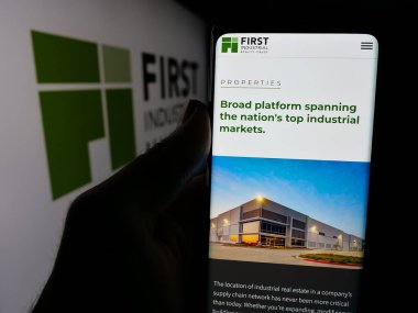 Stuttgart, Almanya - 11-11-2024: ABD 'li şirket First Industrial Realty Trust Inc.' in web sayfası ile cep telefonu logosu önünde ekranda. Telefon ekranının merkezine odaklan.