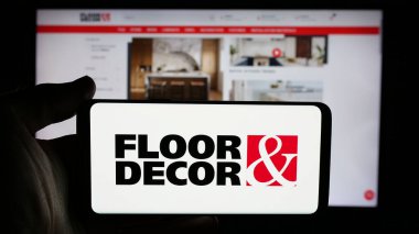 Stuttgart, Almanya - 11-13-2024: ABD 'li döşeme şirketi Floor Holding Inc.' nin logosunun bulunduğu cep telefonu sahibi kişi iş sayfasının önünde ekranda. Telefon ekranına odaklan.