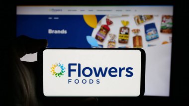 Stuttgart, Almanya - 11-13-2024: ABD 'li fırın gıda şirketi Flowers Foods Corporation' ın logosunun bulunduğu cep telefonu web sayfası önünde ekranda. Telefon ekranına odaklan.