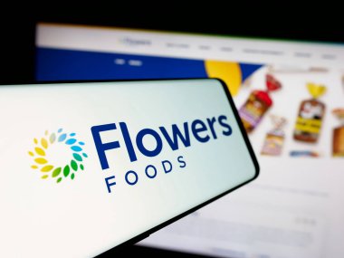 Stuttgart, Almanya - 11-13-2024: ABD 'li fırın gıda şirketi Flowers Foods Corporation' ın logosuna sahip akıllı telefon web sitesinin önünde ekranda. Telefon ekranının merkez soluna odaklan.
