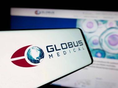 Stuttgart, Almanya - 11-14-2024: Amerikan tıbbi cihaz şirketi Globus Medical Inc. 'in logosunu taşıyan cep telefonu iş sitesinin önünde ekranda. Telefon ekranının soluna odaklan.